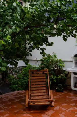 a wooden chair sitting on a patio under a tree at Francesco Terrace - Piazza Bologna, Rome in Rome