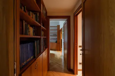 a hallway with wooden bookshelves and a hallway with a door at Francesco Terrace - Piazza Bologna, Rome in Rome