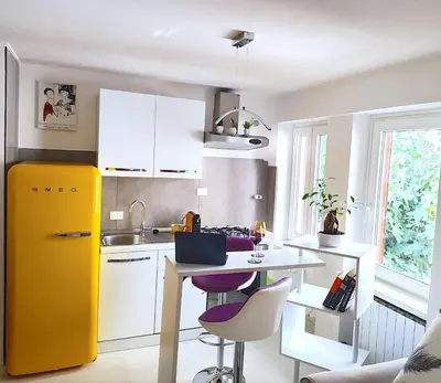 a kitchen with a yellow refrigerator and a table at Fornaci 8 - Loft in Vatican in Rome
