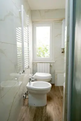 a bathroom with a toilet and a sink and a window at Fornaci 8 - Loft in Vatican in Rome