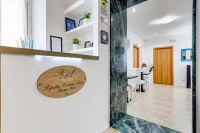 a living room and dining room with a sign on the wall at Ripetta Central Suites in Rome