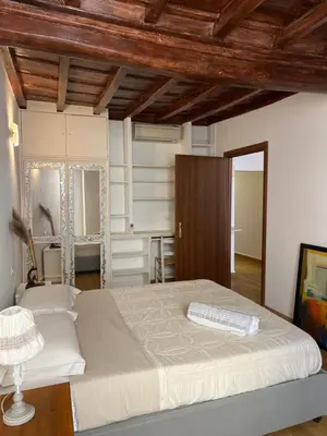 a bedroom with a large bed and a wooden ceiling at Campo dei fiori Suite in Rome