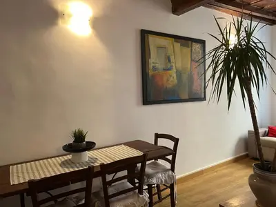 a dining room with a table and a potted plant at Campo dei fiori Suite in Rome