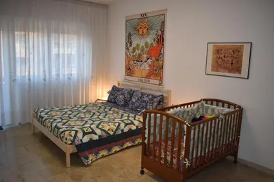 a bedroom with a crib and a painting on the wall at Vacanze Romane in Rome