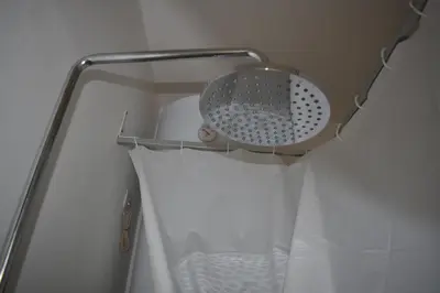 a strainer on a shelf in a shower curtain at Vacanze Romane in Rome
