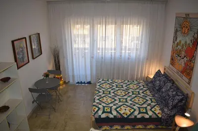 a living room with a bed and a table with chairs at Vacanze Romane in Rome