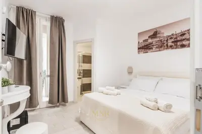 a white bedroom with a bed with towels on it at MysuiteRome in Rome