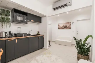 a kitchen with black cabinets and a sink at MysuiteRome in Rome