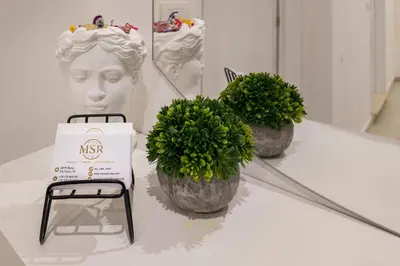 two plants on a table next to a bust of a woman at MysuiteRome in Rome