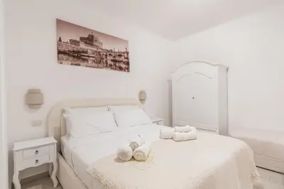 a white bedroom with a bed with towels on it at MysuiteRome in Rome