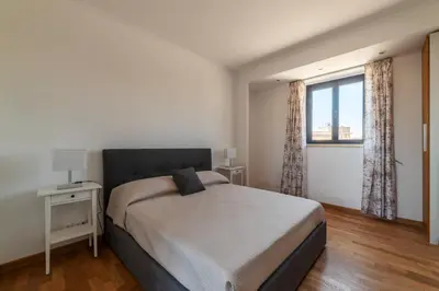 a bedroom with a large bed and a window at GuestHost - MM San Giovanni Apartment in Rome