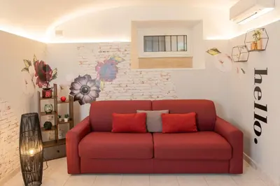 a red couch in a living room with a brick wall at Casa ZOE in Rome