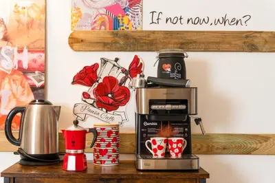 a coffee maker on a table with coffee cups at Casa ZOE in Rome