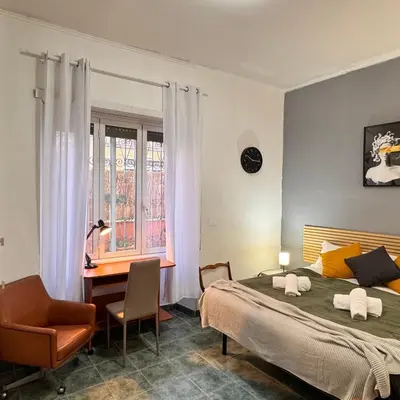 a bedroom with a bed and a desk and a window at Bella Roma Stay in Rome