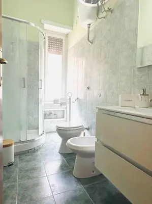 a white bathroom with a toilet and a sink at Bella Roma Stay in Rome