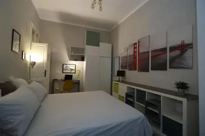 a bedroom with a white bed and some pictures on the wall at Charming house in Rome