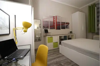 a bedroom with a bed and a desk with a laptop at Charming house in Rome