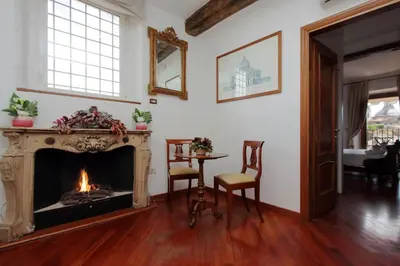 a living room with a fireplace and a table and chairs at Terrazze Navona in Rome