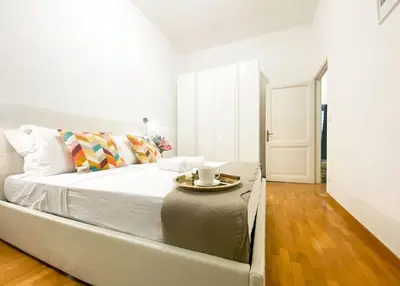 a white bed in a room with a table on it at Via Veneto - Domus Juliae in Rome