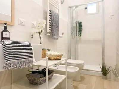 a white bathroom with a toilet and a shower at Via Veneto - Domus Juliae in Rome