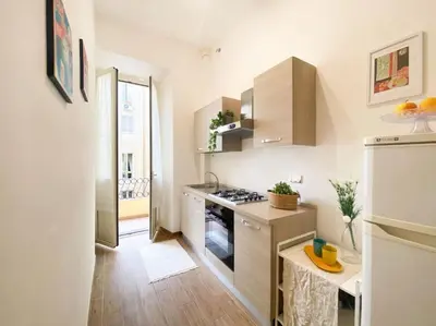 a kitchen with white cabinets and a stove top oven at Via Veneto - Domus Juliae in Rome