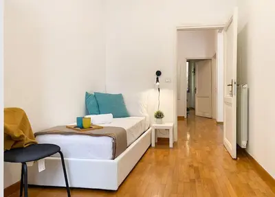 a bedroom with a white bed with blue pillows at Via Veneto - Domus Juliae in Rome