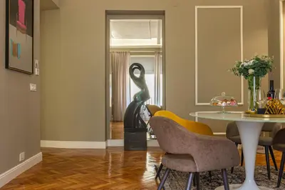 a dining room with a table and two sculptures at RANALLI Suite in Rome