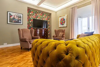 a living room with a yellow couch and chairs at RANALLI Suite in Rome