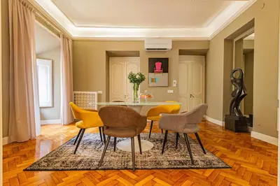 a dining room with yellow chairs and a table at RANALLI Suite in Rome