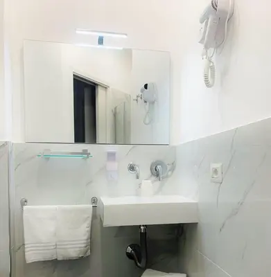 a white bathroom with a sink and a mirror at B&Baldo Vatican in Rome