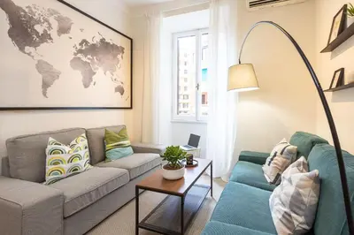 a living room with a couch and a world map on the wall at Vatican Flower Apartment in Rome