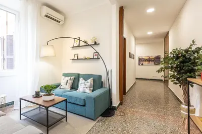 a living room with a blue couch and a table at Vatican Flower Apartment in Rome