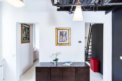 a room with white walls and a wooden table at Trastevere Design Loft - My Extra Home in Rome