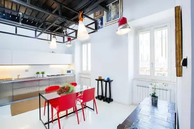 a kitchen and dining room with red chairs and a table at Trastevere Design Loft - My Extra Home in Rome