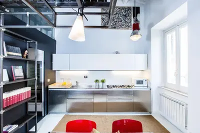 a kitchen with two red chairs and a sink at Trastevere Design Loft - My Extra Home in Rome