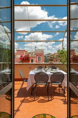 a patio with a table and chairs on a balcony at Coppede' Penthouse in Rome