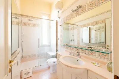 a bathroom with a sink and a toilet and a mirror at Coppede' Penthouse in Rome