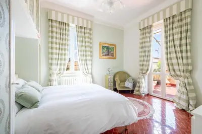 a bedroom with a white bed and two windows at Coppede' Penthouse in Rome