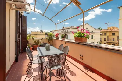 a patio with a table and chairs on a balcony at Coppede' Penthouse in Rome