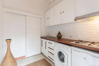 a kitchen with white cabinets and a washer and dryer at Pantheon Splendid Flat with Terrace in Rome