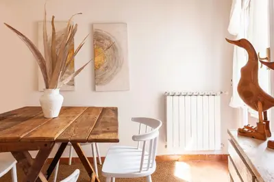 a dining room with a wooden table and white chairs at Pantheon Splendid Flat with Terrace in Rome