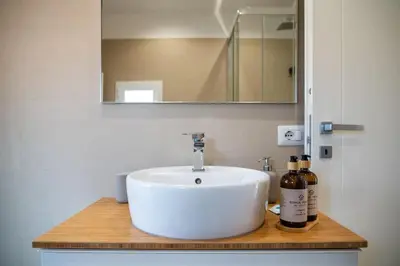 a bathroom with a white sink and a mirror at SKY DOMUS ROME Historic Center Penthouse With Jacuzzi in Rome