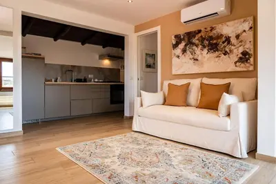 a living room with a white couch and a kitchen at SKY DOMUS ROME Historic Center Penthouse With Jacuzzi in Rome