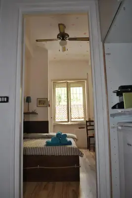 a bedroom with a bed with a ceiling fan and a window at La Casa dei Quattro Venti in Rome