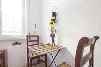 a table with a vase with a sunflower on it at La Casa dei Quattro Venti in Rome