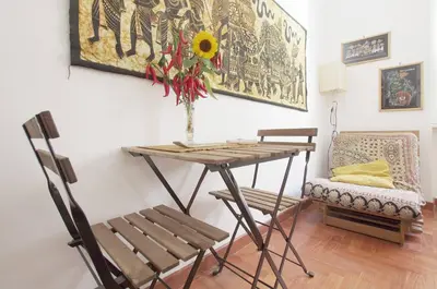 a table and a chair and a vase with a sunflower at La Casa dei Quattro Venti in Rome