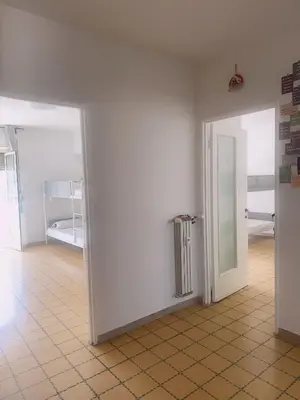 an empty room with two doors and a room with beds at Lisa HOUSE in Rome