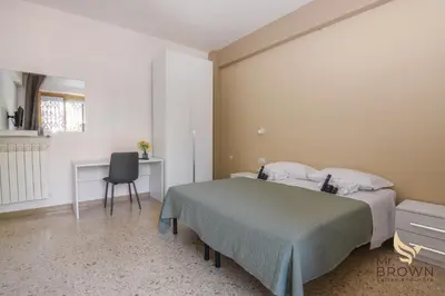 a bedroom with a bed and a desk and a chair at MrBrown - Pincherle Room in Rome
