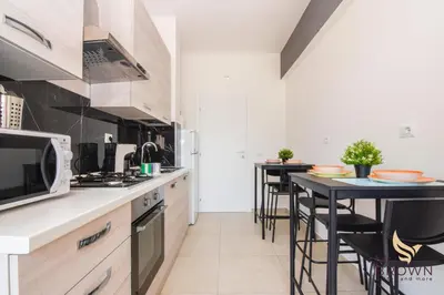 a kitchen with two counters and a table with stools at MrBrown - Pincherle Room in Rome
