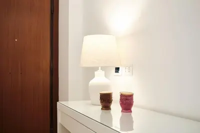 a table with a lamp on top of a dresser at 20 Minuti Vaticano - Nido Romano Shopping Folkoristico by Hôtea in Rome